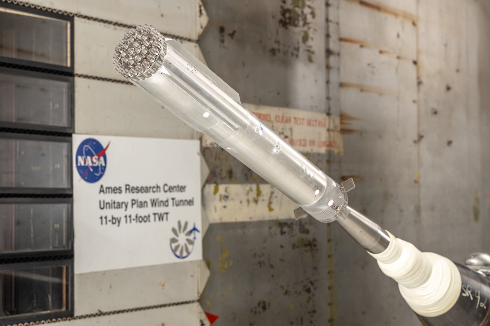 A metal scale model of the Super Heavy booster mounted diagonally in a NASA Ames wind tunnel.